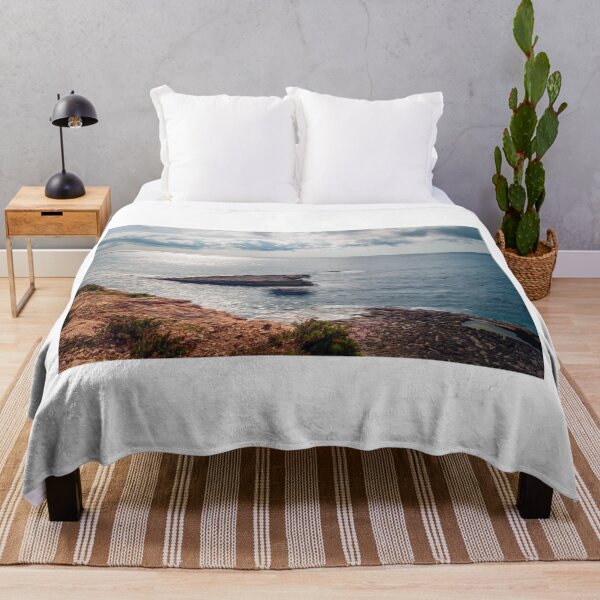 Item preview, Sunlit Rocky Coastline and Small Offshore Island With Calm Ocean Under Cloudy Sky designed and sold by Nmallia.