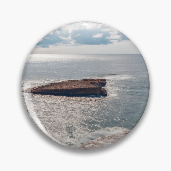 Item preview, Sunlit Rocky Coastline and Small Offshore Island Under Cloudy Sky Over Calm Blue Ocean designed and sold by Nmallia.
