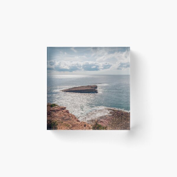 Item preview, Sunlit Rocky Coastline and Small Offshore Island Under Cloudy Sky Over Calm Blue Ocean designed and sold by Nmallia.