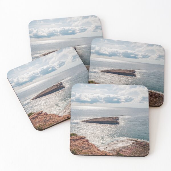 Item preview, Sunlit Rocky Coastline and Small Offshore Island Under Cloudy Sky Over Calm Blue Ocean designed and sold by Nmallia.