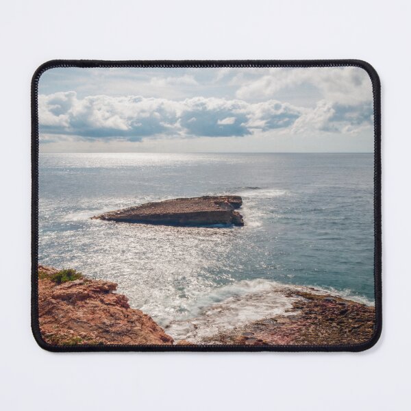 Item preview, Sunlit Rocky Coastline and Small Offshore Island Under Cloudy Sky Over Calm Blue Ocean designed and sold by Nmallia.