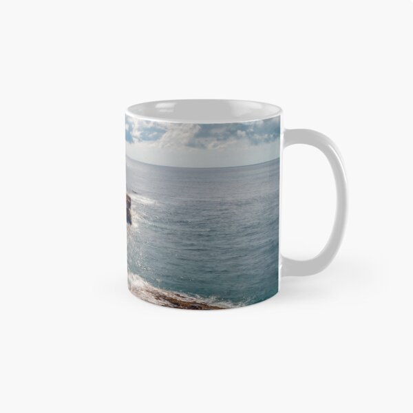 Item preview, Sunlit Rocky Coastline and Small Offshore Island Under Cloudy Sky Over Calm Blue Ocean designed and sold by Nmallia.