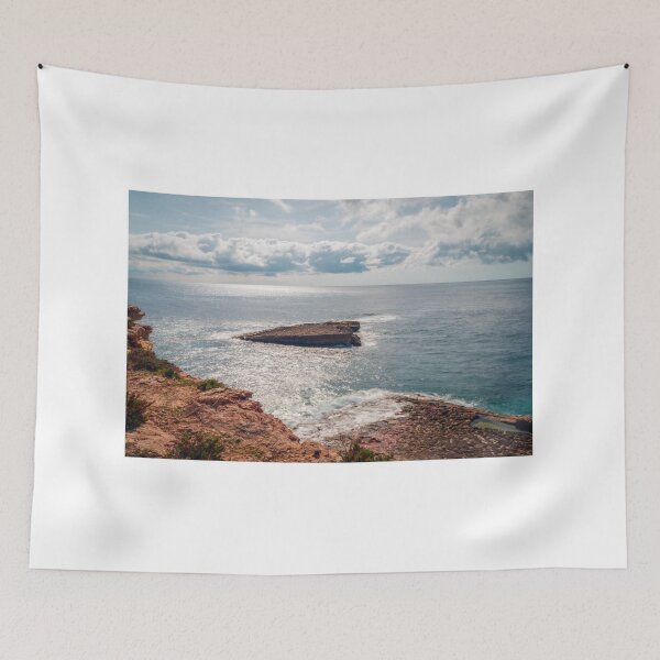 Item preview, Sunlit Rocky Coastline and Small Offshore Island Under Cloudy Sky Over Calm Blue Ocean designed and sold by Nmallia.