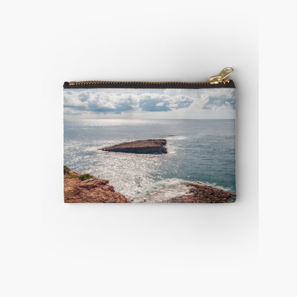 Item preview, Sunlit Rocky Coastline and Small Offshore Island Under Cloudy Sky Over Calm Blue Ocean designed and sold by Nmallia.