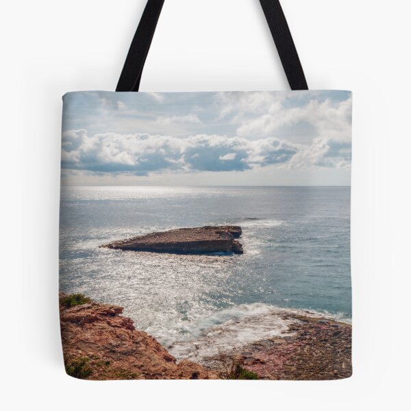 Item preview, Sunlit Rocky Coastline and Small Offshore Island Under Cloudy Sky Over Calm Blue Ocean designed and sold by Nmallia.