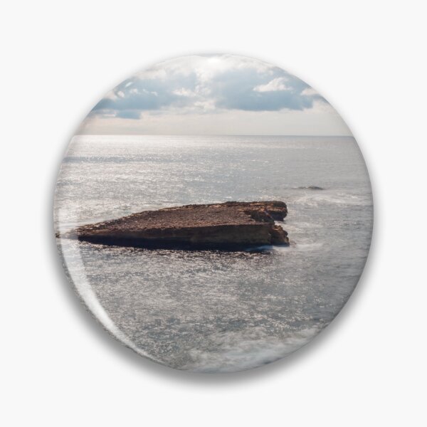 Item preview, Sunlit Rocky Coastline With Small Sea Stack and Calm Ocean Under a Cloudy Sky designed and sold by Nmallia.