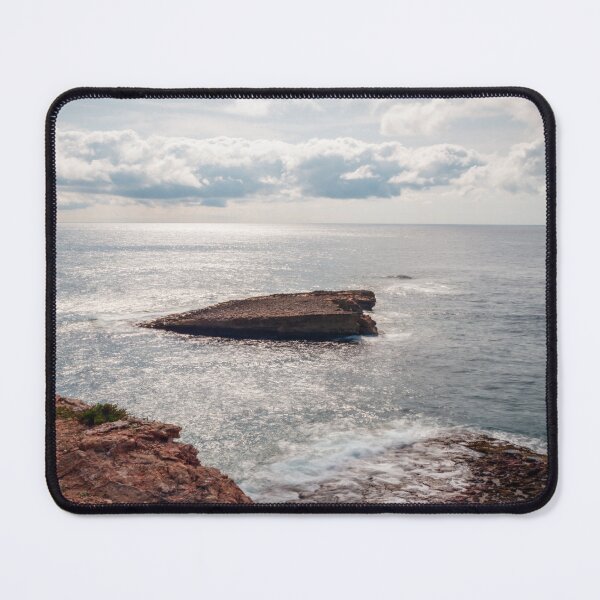 Item preview, Sunlit Rocky Coastline With Small Sea Stack and Calm Ocean Under a Cloudy Sky designed and sold by Nmallia.