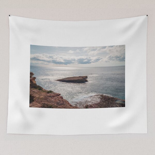 Item preview, Sunlit Rocky Coastline With Small Sea Stack and Calm Ocean Under a Cloudy Sky designed and sold by Nmallia.