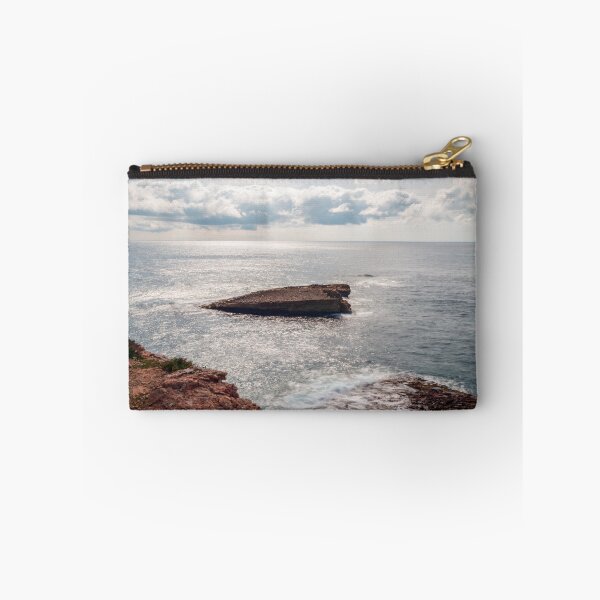 Item preview, Sunlit Rocky Coastline With Small Sea Stack and Calm Ocean Under a Cloudy Sky designed and sold by Nmallia.