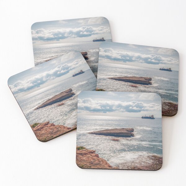 Item preview, Sunlit Rocky Coastline With Cargo Ship on Calm Sea Under Dramatic Cloudy Sky designed and sold by Nmallia.