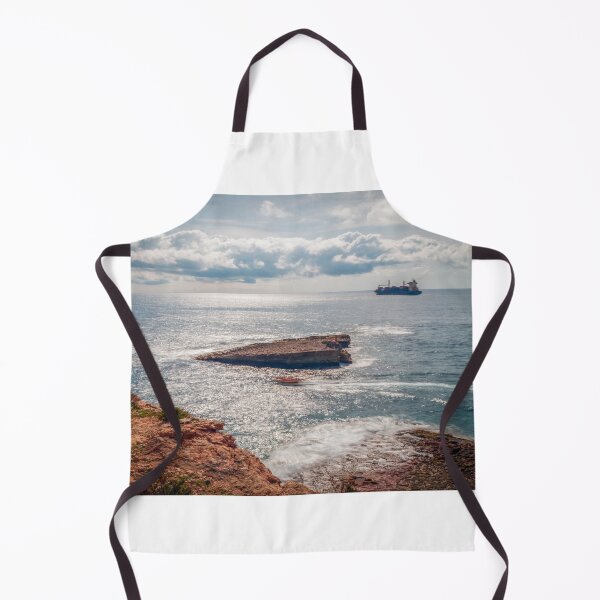 Item preview, Sunlit Rocky Coastline With Cargo Ship on Calm Sea Under Dramatic Cloudy Sky designed and sold by Nmallia.