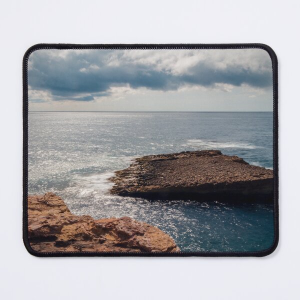 Item preview, Rocky Coastline With Flat Rock Outcrop Extending Into Calm Ocean Under Dramatic Cloudy Sky designed and sold by Nmallia.