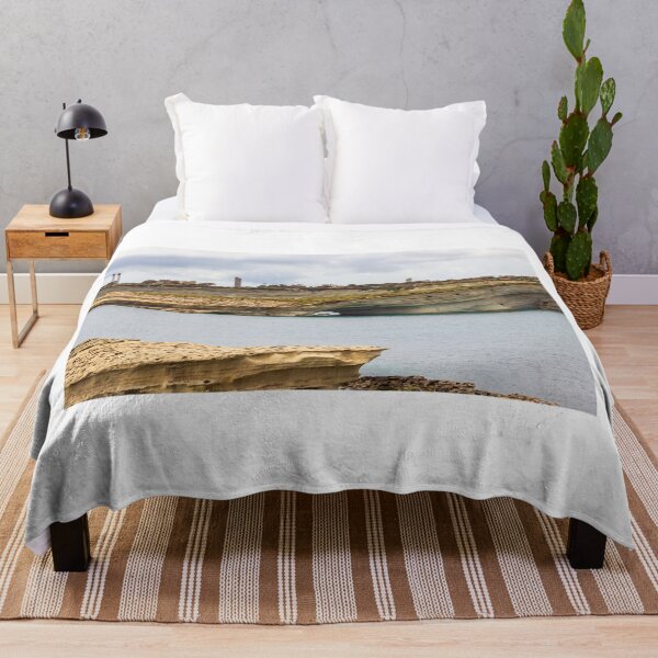 Item preview, Boat Passing Through Natural Coastal Arch Beneath Layered Limestone Cliffs On Calm Sea Under Cloudy Sky designed and sold by Nmallia.