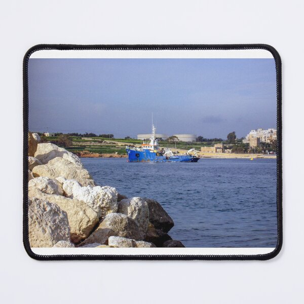 Item preview, Blue Work Boat Near Rocky Coastline With Harbor Buildings and Industrial Tanks Under Blue Sky designed and sold by Nmallia.