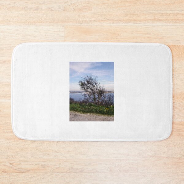 Item preview, Windswept Tree On Coastal Bluff Overlooking Calm Blue Sea With Wildflowers In Foreground designed and sold by Nmallia.