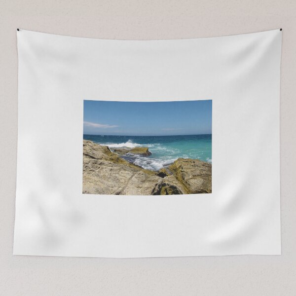 Item preview, Rocky Shoreline With Turquoise Ocean Waves Crashing Against Coastal Rocks Under Clear Blue Sky designed and sold by Nmallia.