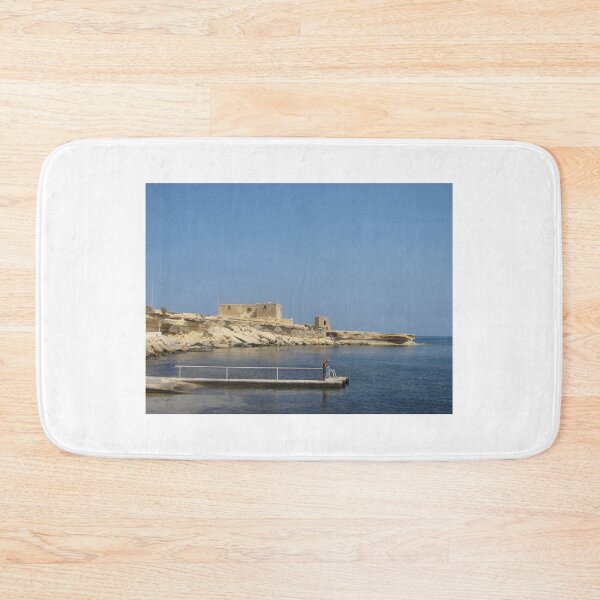 Item preview, Solitary Man On Pier Near Historic Coastal Fort Over Calm Mediterranean Sea On Sunny Day designed and sold by Nmallia.