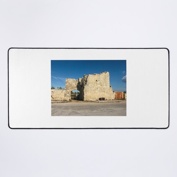 Item preview, Old Stone Ruins With Archway and Rusted Gate Beside Road Under Blue Sky designed and sold by Nmallia.