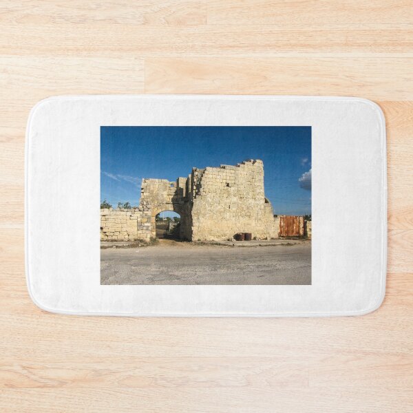 Item preview, Old Stone Ruins With Archway and Rusted Gate Beside Road Under Blue Sky designed and sold by Nmallia.