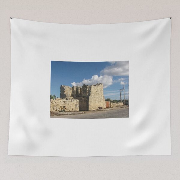 Item preview, Old Stone Ruins With Archway and Rusted Gate Beside Road Under Blue Sky designed and sold by Nmallia.