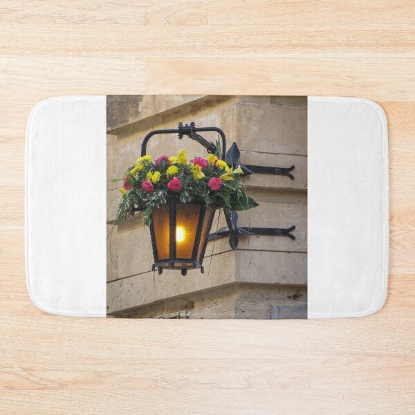 Item preview, Vintage Wall Lantern With Bright Floral Arrangement Hanging On A Stone Street Corner designed and sold by Nmallia.