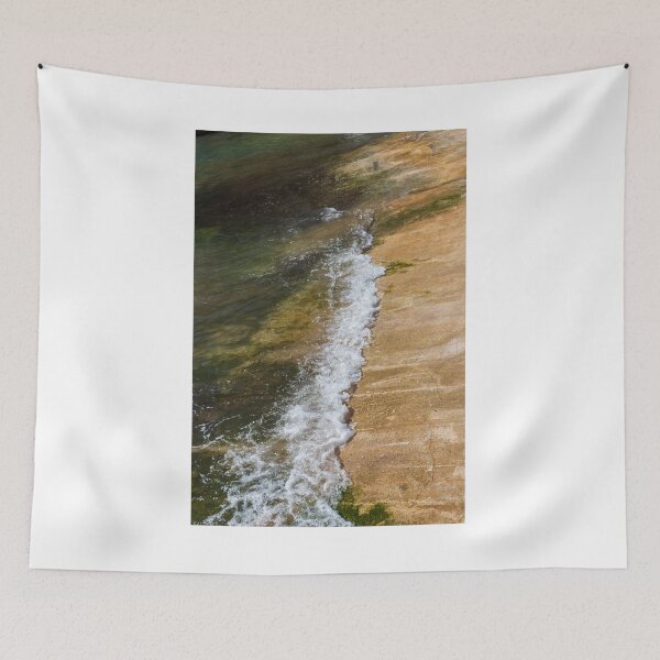 Item preview, Gentle Wave Lapping Against Rocky Shore With Sea Foam and Algae on Sunlit Coastline designed and sold by Nmallia.