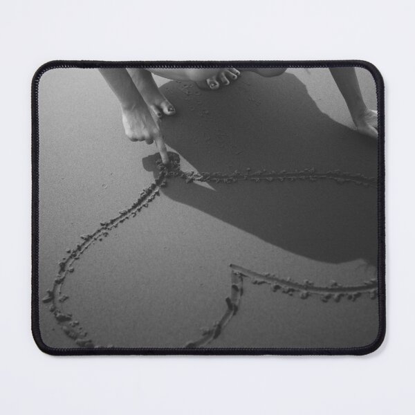 Item preview, Drawing heart in the sand at the beach black and white romantic photographic art print designed and sold by Astrid Arkhangelsky.