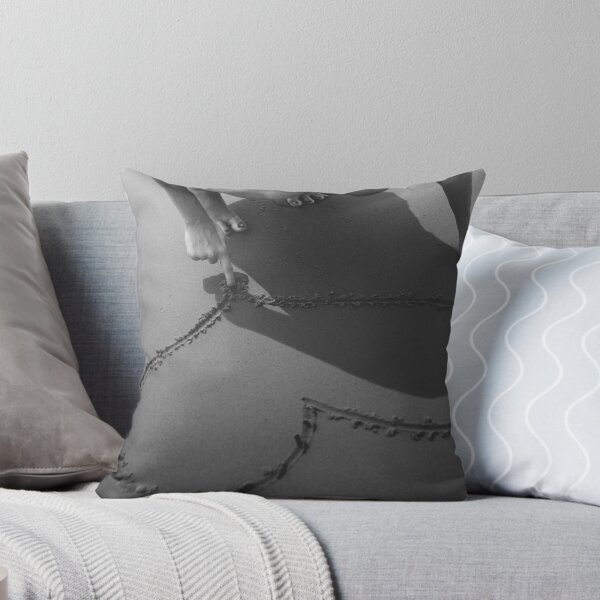 Item preview, Drawing heart in the sand at the beach black and white romantic photographic art print designed and sold by Astrid Arkhangelsky.