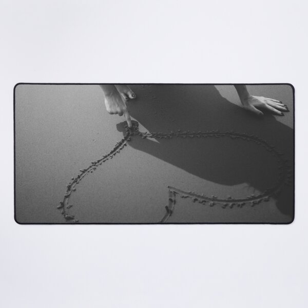 Item preview, Drawing heart in the sand at the beach black and white romantic photographic art print designed and sold by Astrid Arkhangelsky.
