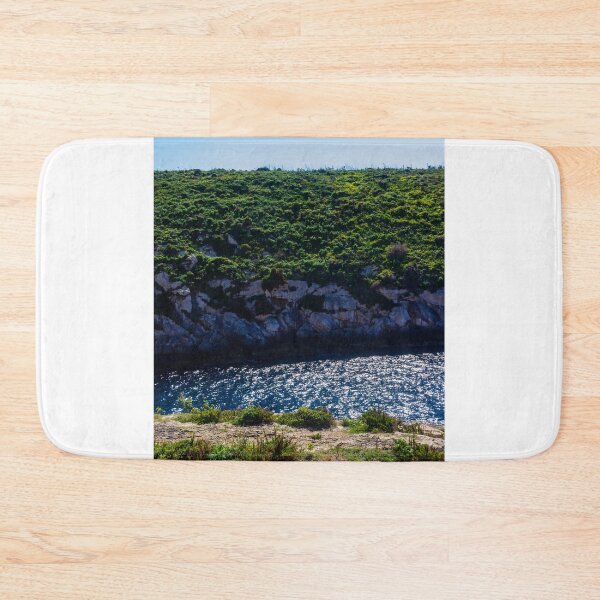 Item preview, Green Coastal Cliff Over Sparkling Blue Sea With Rocky Shoreline On Sunny Summer Day designed and sold by Nmallia.