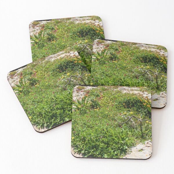 Item preview, Coastal Wildflowers On A Rocky Shore With Lush Green Vegetation And Sunlit Rocks designed and sold by Nmallia.