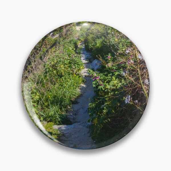 Item preview, Narrow Rocky Path Along Green Hillside With Wildflowers and Old Stone Bridge in Sunlight designed and sold by Nmallia.