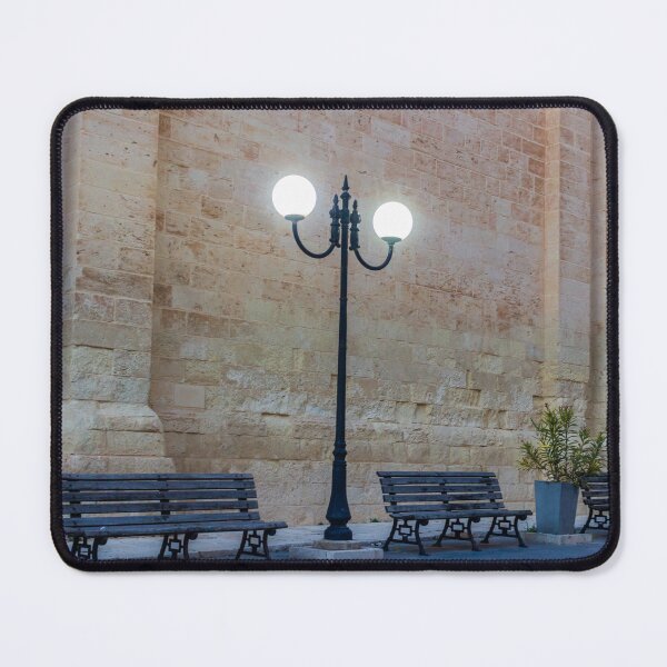 Item preview, Historic Stone Wall With Lamppost and Empty Benches Along Quiet Urban Street at Dusk designed and sold by Nmallia.