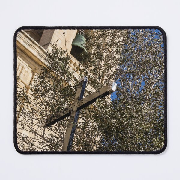 Item preview, Wooden Cross and Olive Tree in Front of Historic Church Bell Tower Against Blue Sky designed and sold by Nmallia.