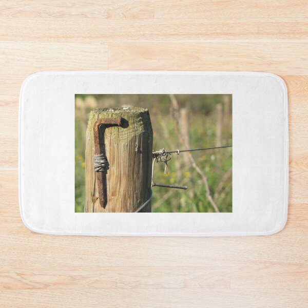 Item preview, Rusty Nail and Barbed Wire On Weathered Wooden Fence Post in Sunny Rural Countryside Close-Up designed and sold by Nmallia.