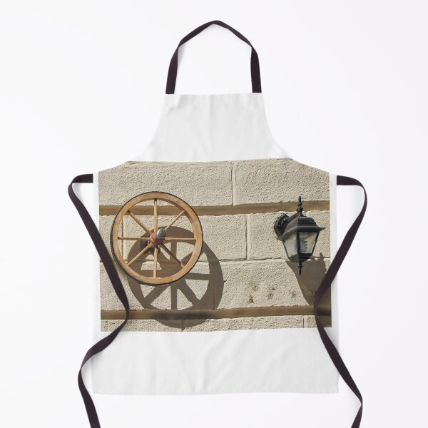 Item preview, Vintage Wooden Wheel and Lantern Mounted on Sunlit Stone Wall Casting Strong Shadow designed and sold by Nmallia.