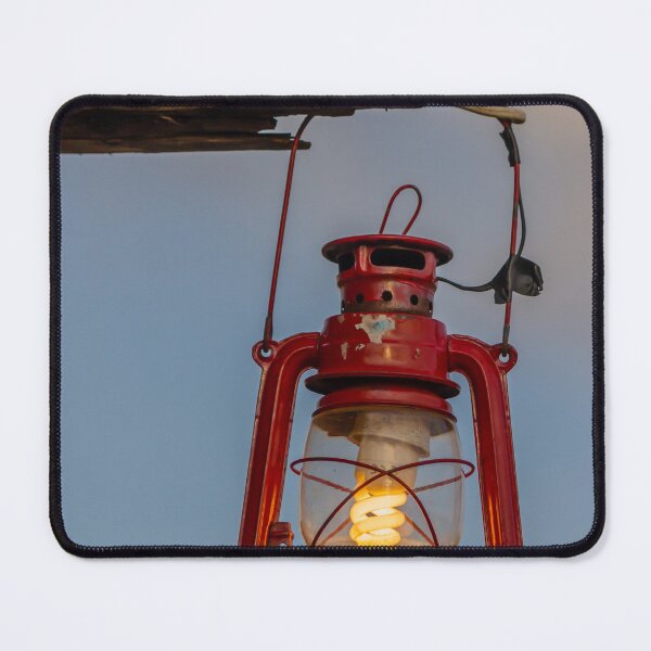 Item preview, Red Vintage Lantern Hanging From Weathered Wood With Warm Glowing Bulb At Dusk designed and sold by Nmallia.