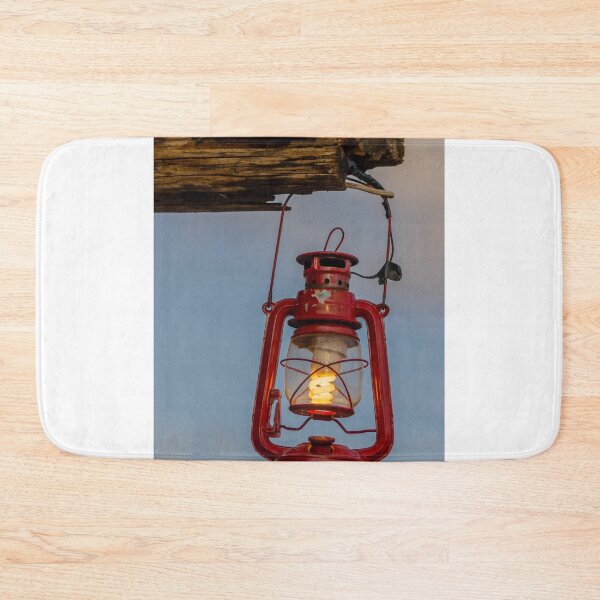 Item preview, Red Vintage Lantern Hanging From Weathered Wood With Warm Glowing Bulb At Dusk designed and sold by Nmallia.