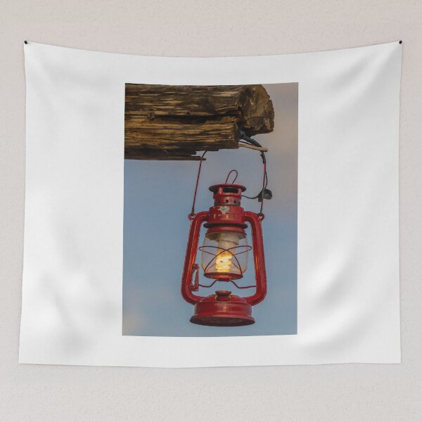 Item preview, Red Vintage Lantern Hanging From Weathered Wood With Warm Glowing Bulb At Dusk designed and sold by Nmallia.