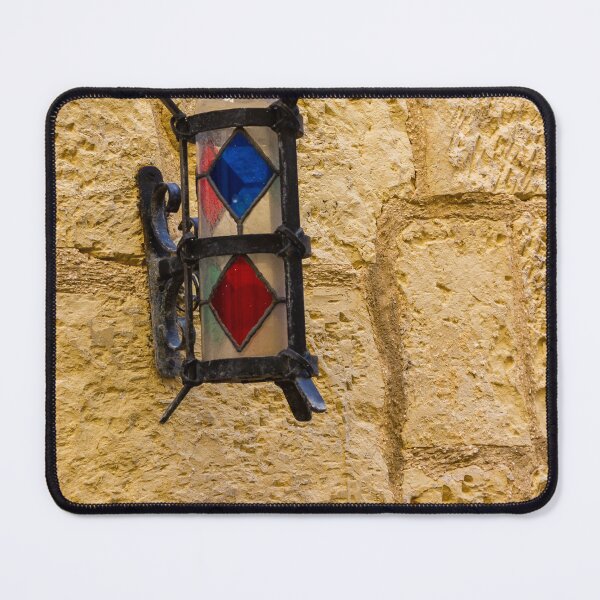Item preview, Vintage Stained Glass Wall Lantern Mounted On Weathered Stone Wall In Sunny Alleyway designed and sold by Nmallia.