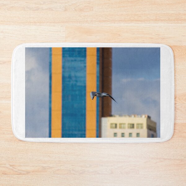 Item preview, Seagull In Flight Over Urban Cityscape With Colorful High-Rise Buildings And Cloudy Sky designed and sold by Nmallia.