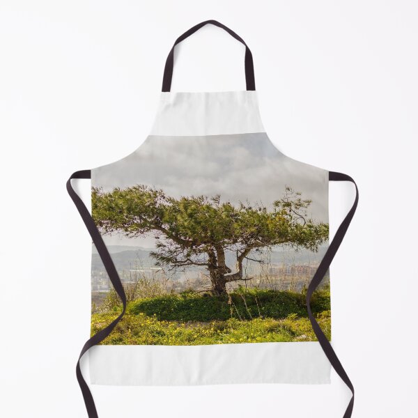 Item preview, Windswept Lone Tree on a Green Hillside Overlooking Distant Town and Valleys Under Cloudy Sky designed and sold by Nmallia.