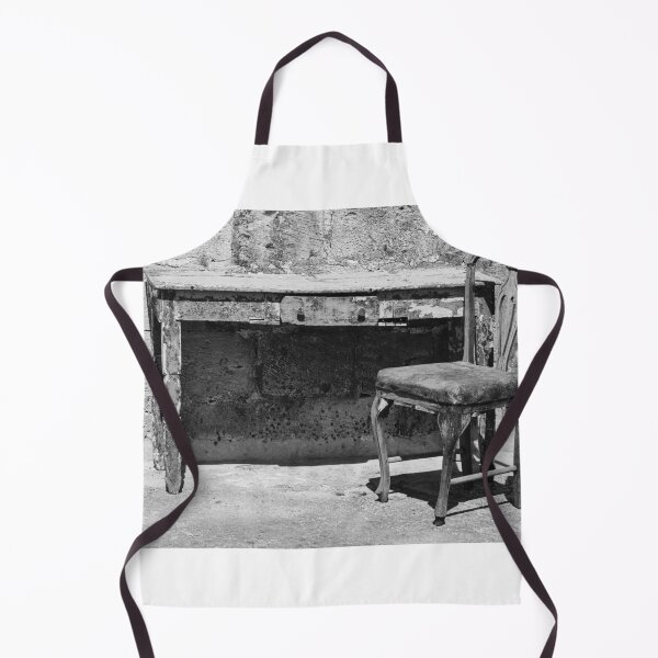 Item preview, Weathered Vintage Chair And Rustic Desk Against Textured Stone Wall In Monochrome Outdoor Scene designed and sold by Nmallia.