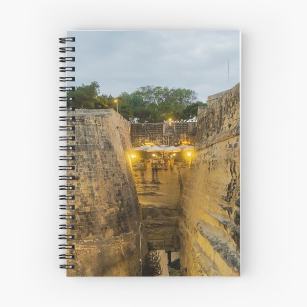 Item preview, Historic Stone Fortress Walls With Lit Terrace Cafe And Narrow Moat At Dusk designed and sold by Nmallia.