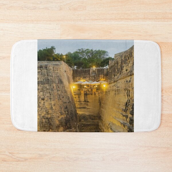 Item preview, Historic Stone Fortress Walls With Lit Terrace Cafe And Narrow Moat At Dusk designed and sold by Nmallia.