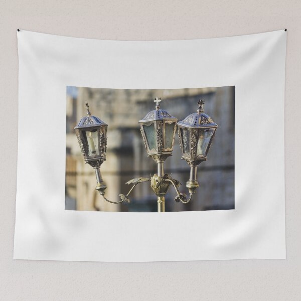 Item preview, Ornate Vintage Brass Lantern With Lit Candle Outside Historic Church — Three-Arm Decorative Street Lamp designed and sold by Nmallia.