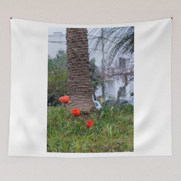 Item preview, Red Poppies Blooming In An Urban Garden Next To A Palm Tree Trunk On A Spring Day designed and sold by Nmallia.