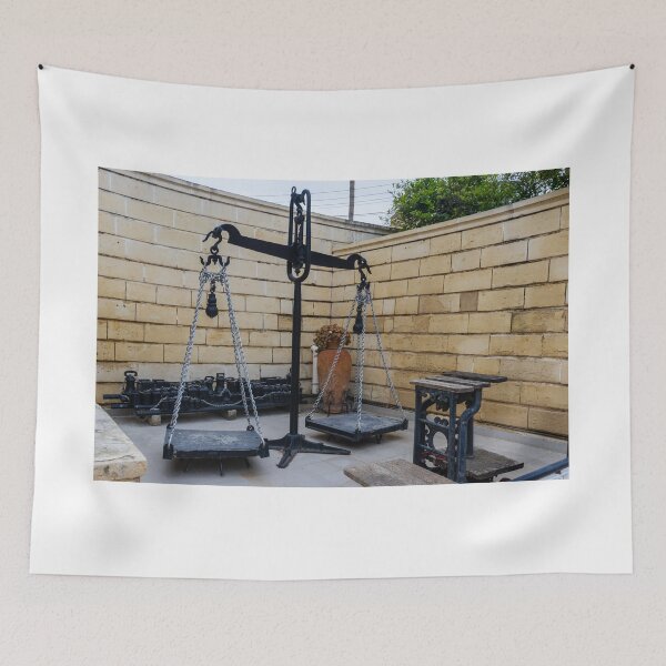 Item preview, Antique Metal Balance Scale With Chains and Platforms in Stone-Walled Courtyard Display designed and sold by Nmallia.