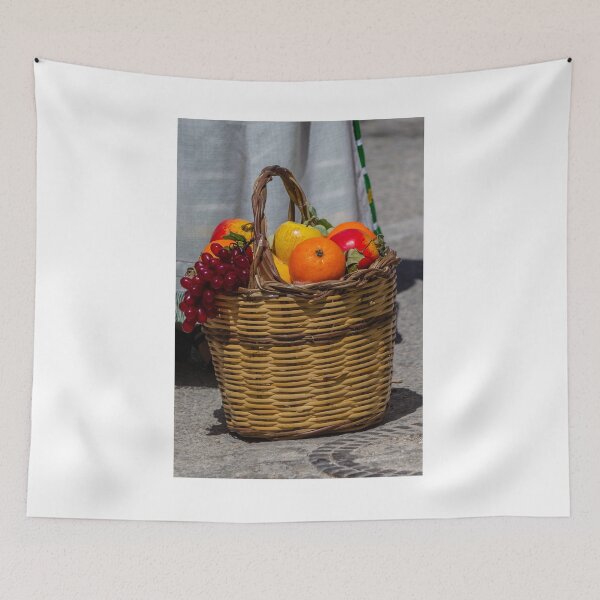 Item preview, Wicker Fruit Basket With Oranges, Apples and Grapes On Stone Pavement Outdoors designed and sold by Nmallia.
