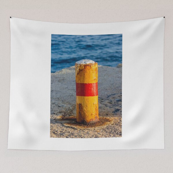 Item preview, Rusty Yellow and Red Bollard on Sunny Harbor Pier With Blue Sea and Weathered Texture designed and sold by Nmallia.
